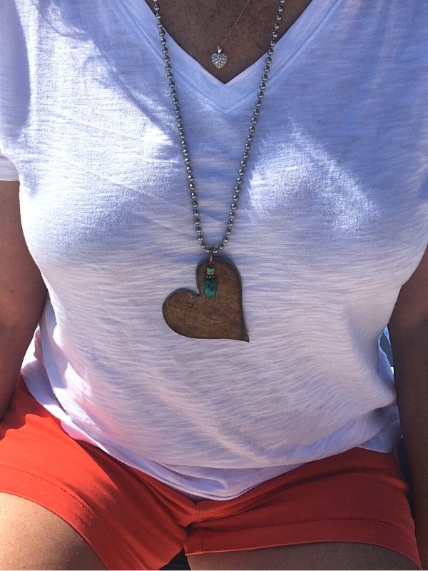 wearing shorts and a big copper heart necklace